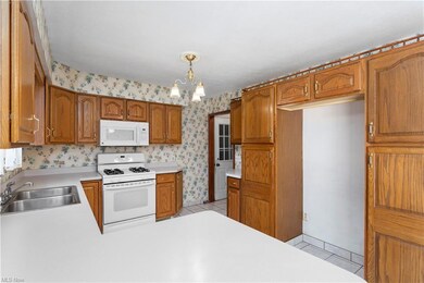 Kitchen  light countertops, white appliances, and 