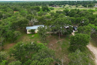 Aerial view of property and surrounding area with a forest