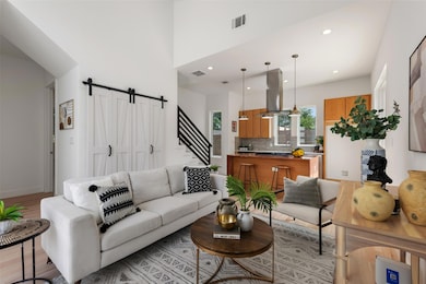 Living room with light wood-style flooring, a bar