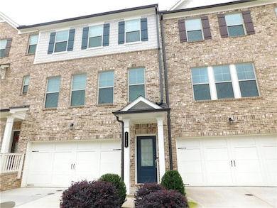 View of front of home featuring driveway, an attached garage, and brick siding