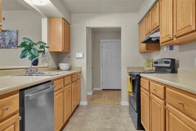 Kitchen with range with electric cooktop, dishwasher, light countertops, under cabinet range hood, and light tile patterned floors
