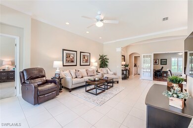 Living area with ceiling fan, arched walkways, orn