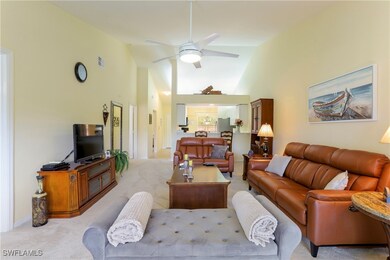 Living room featuring ceiling fan, light carpet, a