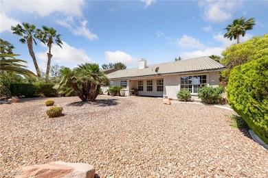 Rear view of house with stucco siding, a tile roof