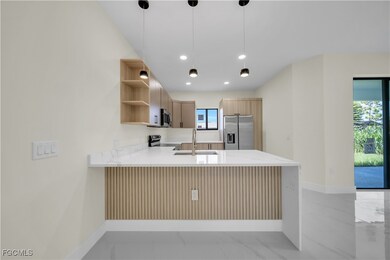 Kitchen with stainless steel fridge with ice dispenser, open shelves, a peninsula, electric range oven, and light marble finish floors