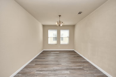 Spacious dining room adorned with a chandelier.
