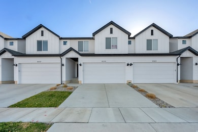 Modern inspired farmhouse with board and batten siding, driveway, and an attached garage