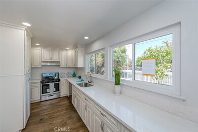 Kitchen is remodeled with new Antique White kitchen cabinets, new quartz counter top, new stove and range hood, new dishwasher, new garbage disposal, new stainless steel sink and faucet, and new recessed lights.