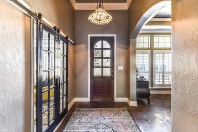 Foyer entrance with crown molding and a barn door
