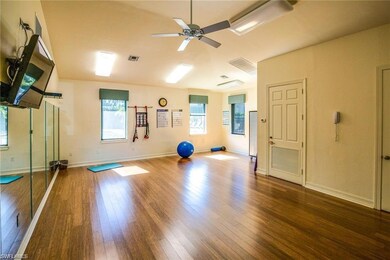 Exercise room with wood-type flooring, ceiling fan