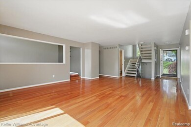 Unfurnished living room featuring stairs and light wood finished floors