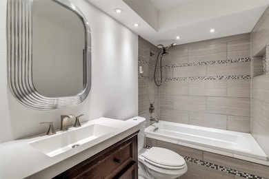Full bathroom with vanity, recessed lighting, and tiled shower / bath