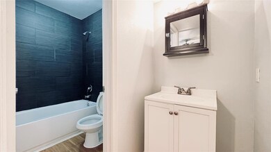 Full bathroom featuring vanity, wood finished flo