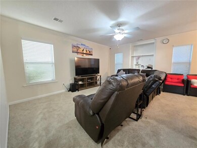 Living room featuring carpet flooring, ceiling fan, crown molding, and built in shelves
