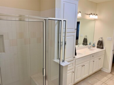 Full bathroom with double vanity, a stall shower,