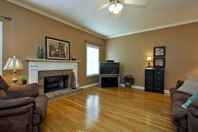 Great Room with Brick Surround Fire Place and Hardwood Flooring. This is just one of TWO FIREPLACES in this Well Appointed Home.