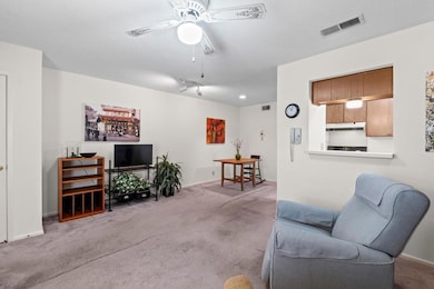 Living room featuring a ceiling fan, carpet floor