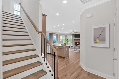 Stairway featuring visible vents, a stone fireplace, a ceiling fan, recessed lighting, and wood finished floors