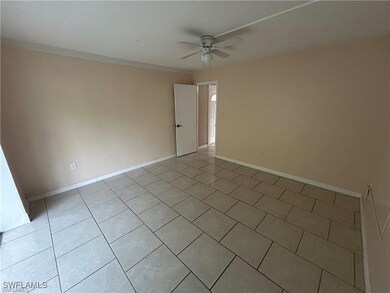 Empty room with ceiling fan and light tile pattern