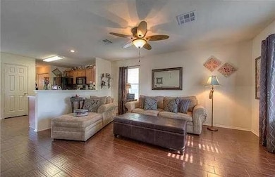 Living area featuring a ceiling fan, wood finishe