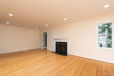 Unfurnished living room featuring light hardwood /