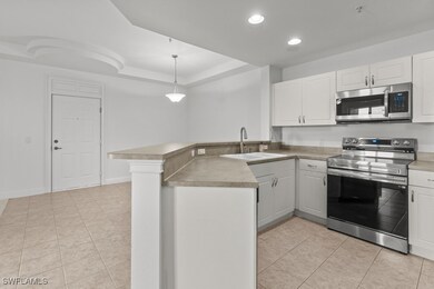 Kitchen featuring a peninsula, white cabinets, sta