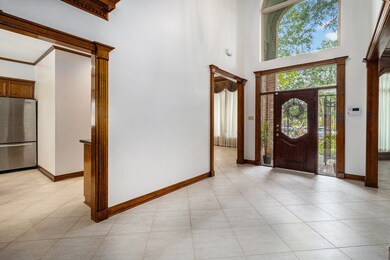 Spacious foyer with wood front door and glass acce