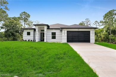 Prairie-style home featuring a front lawn, concrete driveway, an attached garage, and a shingled roof