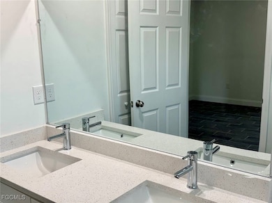 Bathroom with double vanity and wood finished floors