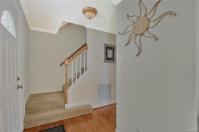 Foyer with wood floor, crown molding, updated half