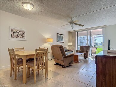 Dining space with ceiling fan, light tile patterned floors, baseboards, and a textured ceiling