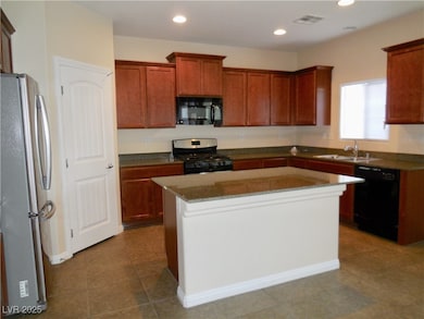 Kitchen with black appliances, a sink, a kitchen i