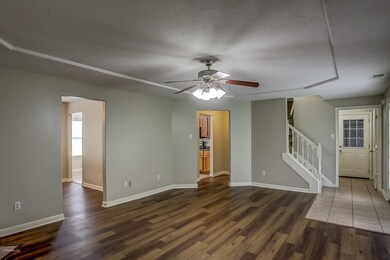 Unfurnished living room with dark hardwood / wood-style flooring and ceiling fan
