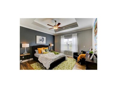 Spacious master bedroom has wood floors and ceilin