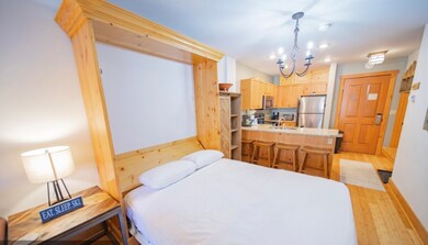 Bedroom featuring baseboards, a sink, light wood f