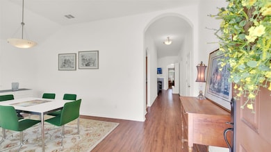 Dining area featuring arched walkways, wood finis