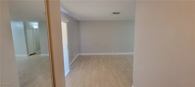 Hall with light wood-style floors, a textured ceil
