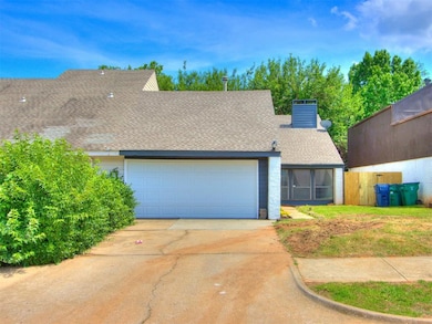 View of front of house with a garage, driveway, roof with shingles, and a chimney