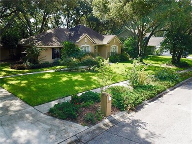 FRONT VIEW OF THE HOUSE WITH LUSH LANDSCAPING.