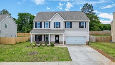 View of front of house with a porch, a garage, con