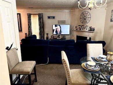 Carpeted living room featuring crown molding, a te