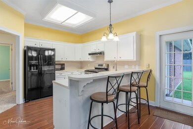 Kitchen with kitchen peninsula, white cabinets, ha