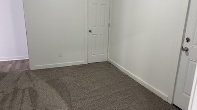 Bedroom with baseboards and dark colored carpet