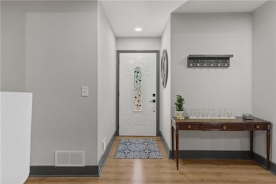 Foyer entrance with light wood-style floors, baseboards, and recessed lighting