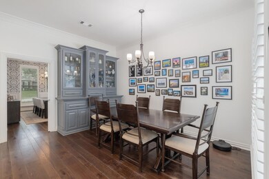 Dining space featuring a chandelier, crown molding, and dark hardwood / wood-style flooring
