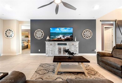 Tiled living room featuring ceiling fan and a barn