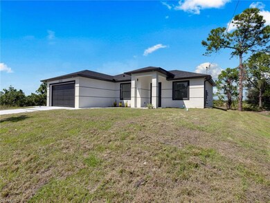 Prairie-style house featuring a front lawn, an attached garage, driveway, and stucco siding