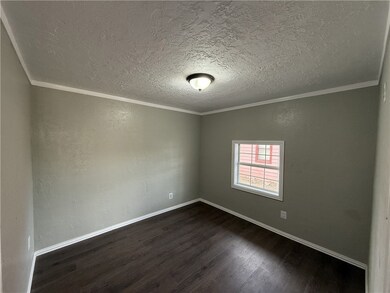 Spare room featuring a textured ceiling, dark wood