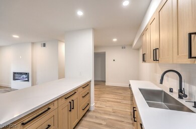Kitchen with light wood-style flooring, a sink, ba