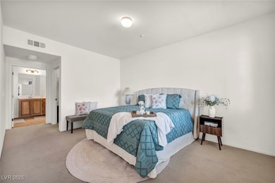 Carpeted bedroom with connected bathroom and baseb